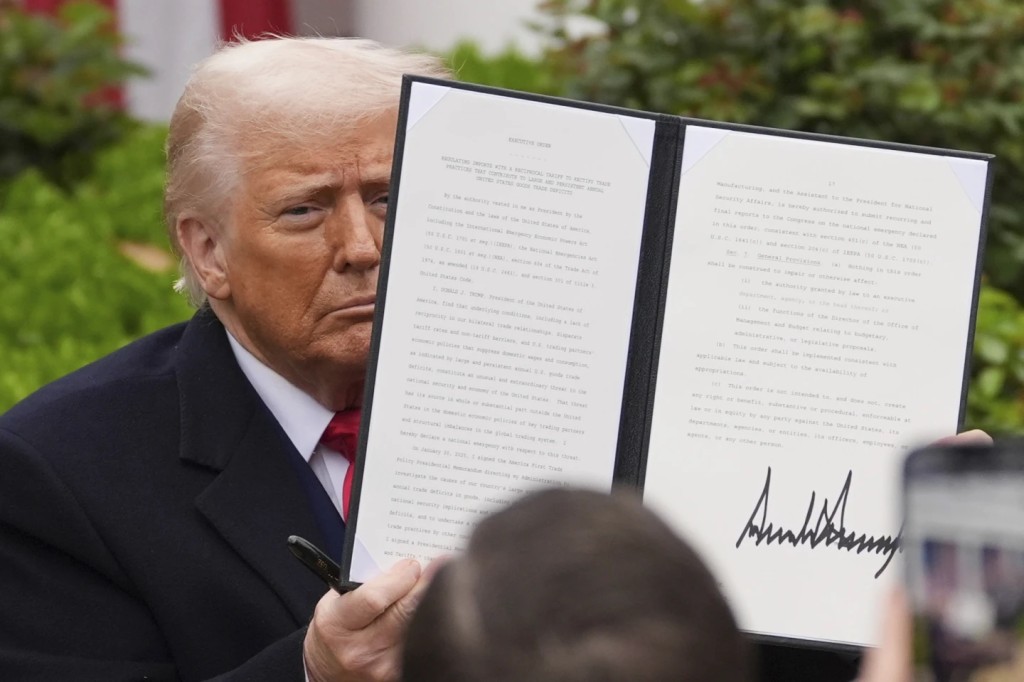 President Donald Trump holds a signed executive order during an event to announce new tariffs in the Rose Garden of the White House, Wednesday, April 2, 2025, in Washington. (AP Photo/Evan Vucci)