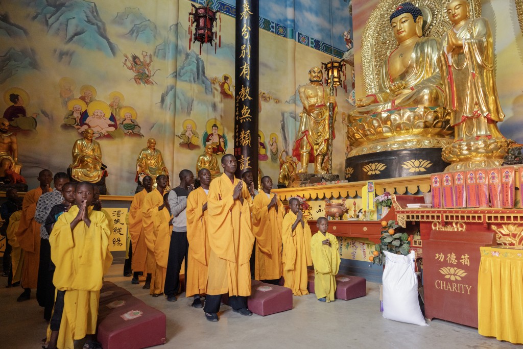 Photo by GIANLUIGI GUERCIA / AFP  Shaolin temple students and monks perform a prayer at a Shaolin Temple outside Lusaka, on August 8, 2026.
