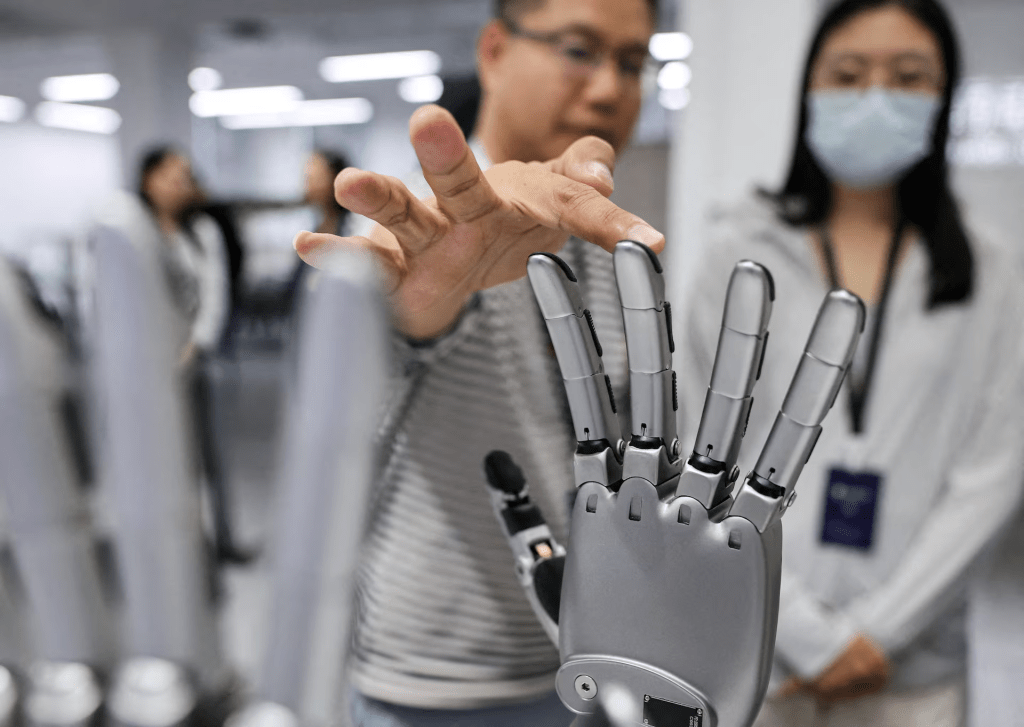 A man touches a robotic hand displayed at the demonstration area at the office of Linkerbot, in Beijing, China, April 27, 2026. REUTERS/Maxim Shemetov/File Photo 
