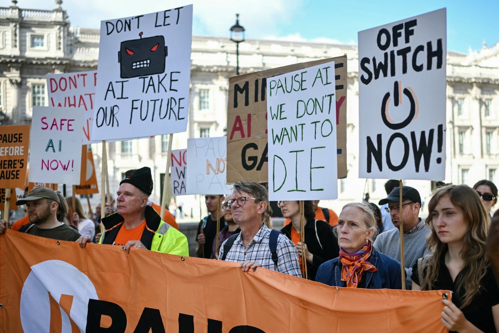Photo by JUSTIN TALLIS / AFP People hold placards during a "emergency protest" by civic action group PauseAI UK outside Downing Street in central London on September 16, 2026, after news that AI researcher Jacob Coxon has decided to leave the industry.