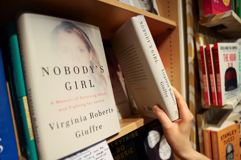 A shop assistant places copies of "Nobody's Girl: A Memoir of Surviving Abuse and Fighting for Justice", the posthumously published memoir by Virginia Giuffre, a prominent accuser of convicted sex offender Jeffrey Epstein, on a shelf at a Foyles bookshop in London, Britain, October 21, 2025. REUTERS/Isabel Infantes