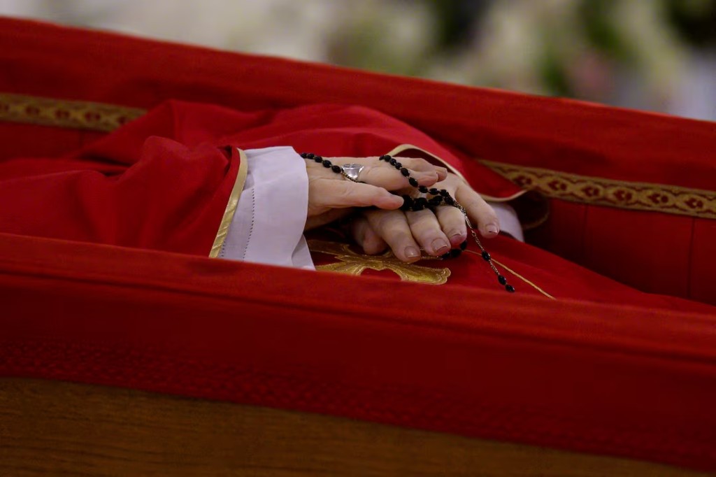A rosary is seen as the body of Pope Francis is placed in an open casket during the rite of the declaration of death in Santa Marta residence at the Vatican, April 21, 2025. (Reuters)