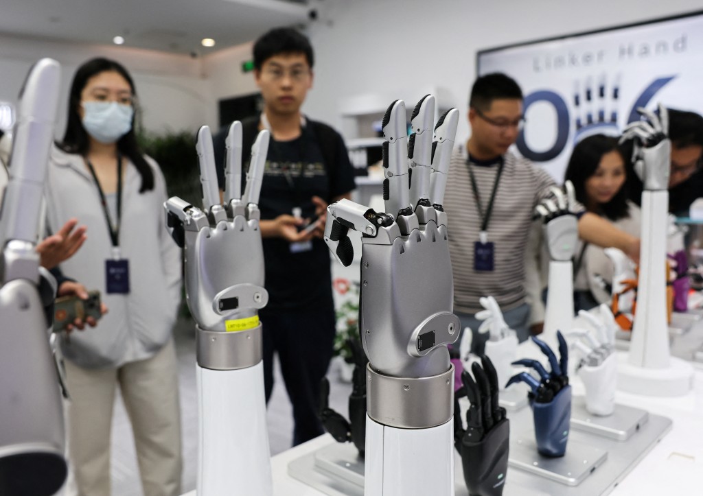 A group of visitors look at robotic hands displayed at the demonstration area of Linkerbot? office, in Beijing, China, April 27, 2026. REUTERS/Maxim Shemetov
