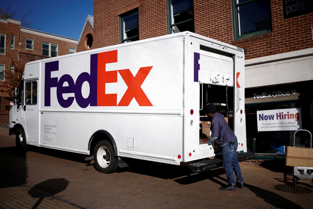 A driver of FedEx loads packages into a delivery truck during Black Friday preparations in the Georgetown neighborhood of Washington, U.S., November 26, 2024. REUTERS/Benoit Tessier
