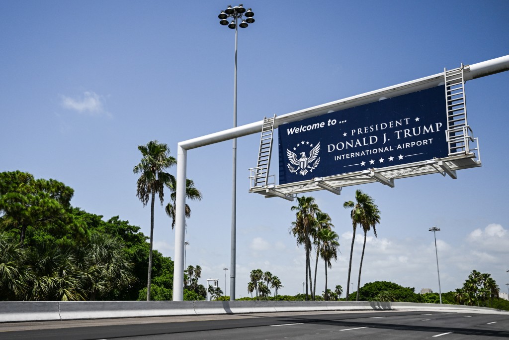 Photo by CHANDAN KHANNA / AFP  A new welcome sign reading "Donald J. Trump International Airport" is seen at the airport's main entrance ramp in West Palm Beach, Florida, on July 9, 2026.