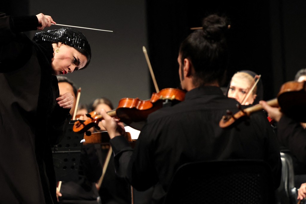 TOPSHOT - Paniz Faryoussefi, the first woman to conduct the Tehran Symphony Orchestra, leads the ensemble at the Vahdat Hall in Tehran on November 13, 2025. (Photo by AFP)