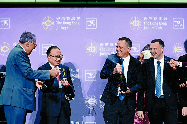 Fownes, second right, pops champagne to celebrate a major milestone in his training career.