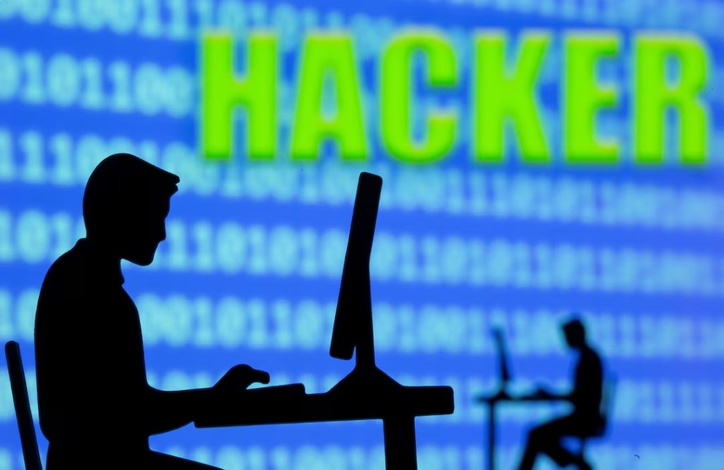 A 3D printed model of men working on computers are seen in front of displayed binary code and words "Hacker" in this illustration taken, July 5, 2021. REUTERS/Dado Ruvic/Illustration/File Photo