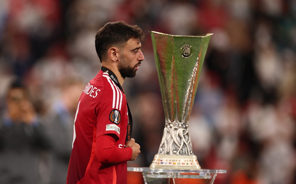 Manchester United's Bruno Fernandes looks dejected as he walks past the trophy after collecting his runners up medal. (Reuters)