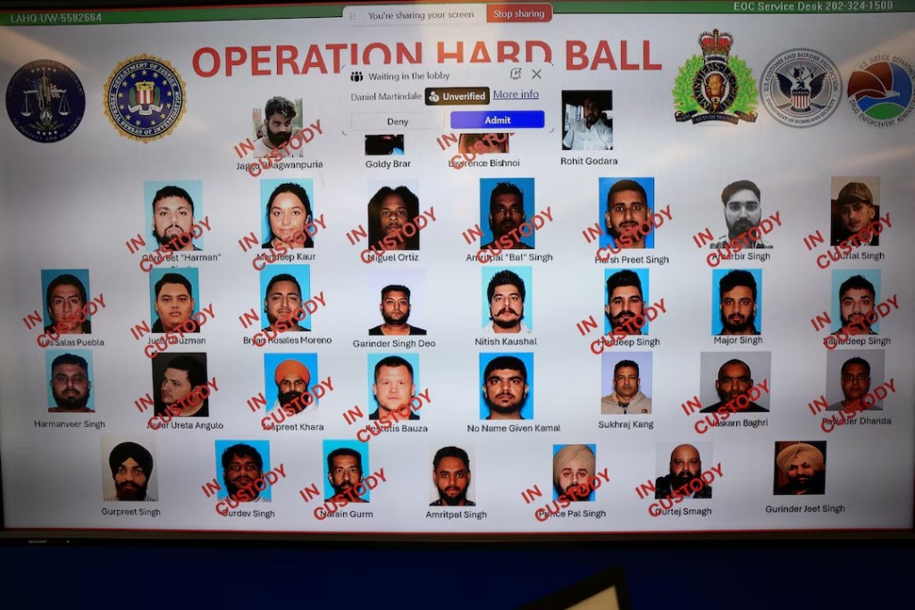 ] A screen displays images of images of people in custody, as U.S. and Canadian law enforcement officials announce federal charges and arrests of alleged members of a transnational organized crime group, at FBI offices in Los Angeles, California, U.S. July 7, 2026. REUTERS/David Swanson