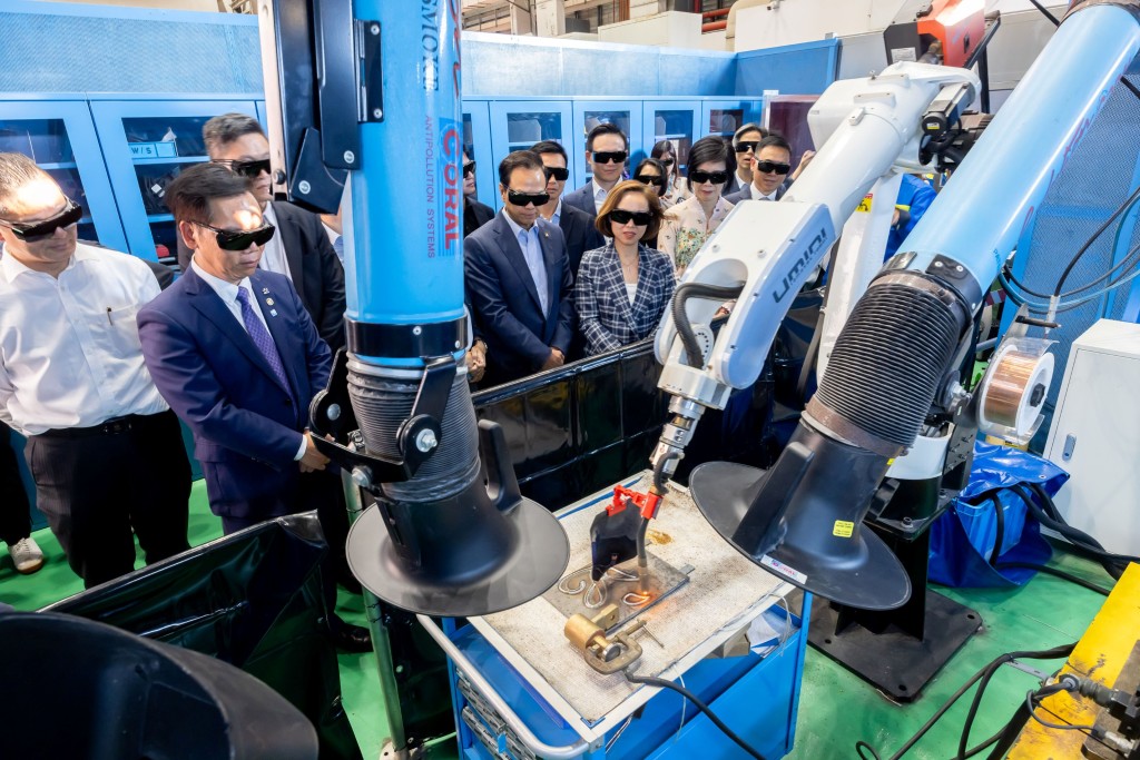 Legislators watch a welding robot demonstration to learn how the robot completes welding tasks quickly and precisely. They also pose for a photo holding a metal plate welded with the LegCo emblem. Legislators watch a welding robot demonstration to learn how the robot completes welding tasks quickly and precisely. They also pose for a photo holding a metal plate welded with the LegCo emblem.