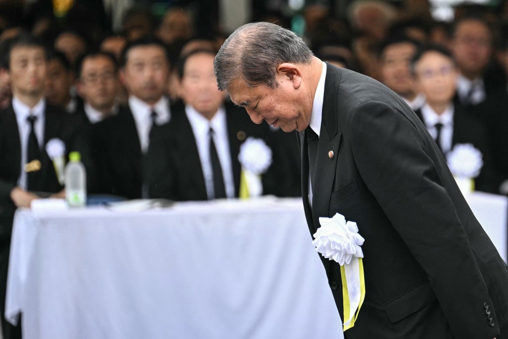 Japan's Prime Minister Shigeru Ishiba bows as he approaches the podium to give a speech during the annual memorial ceremony for the victims at the Peace Park in Nagasaki on August 9, 2025, to mark the 80th anniversary of the atomic bombing during WWII. (Photo by Philip FONG / AFP)