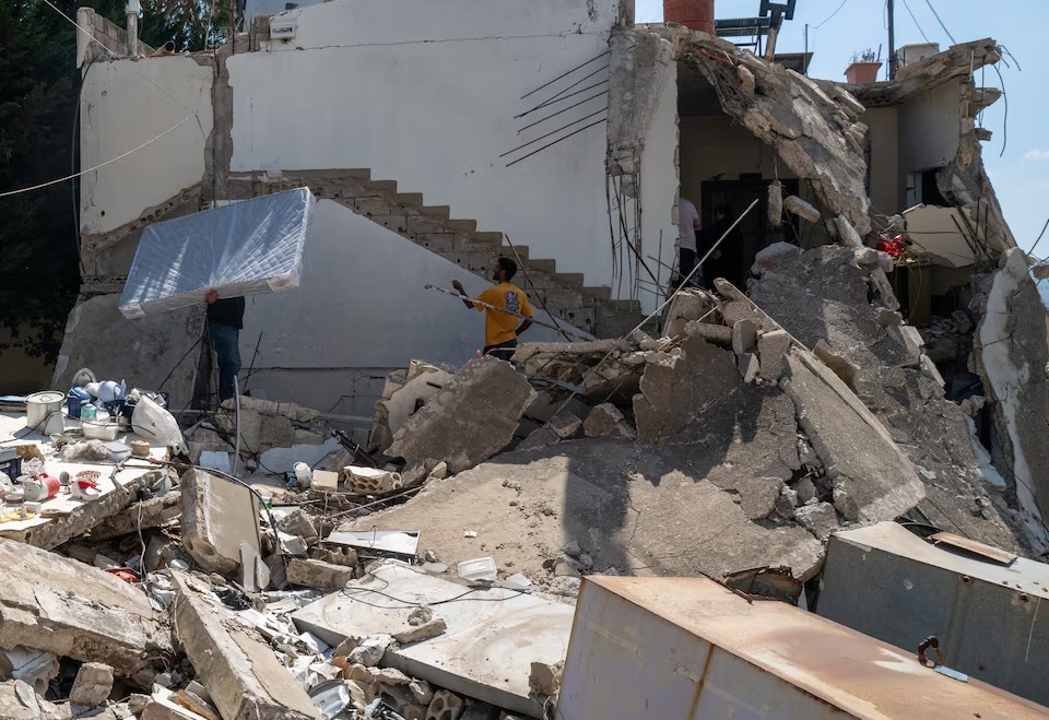 A displaced Lebanese man who survived an Israeli airstrike carries a mattress as he returns to his house damaged by an airstrike, following the U.S.-Iran deal, in Nabatieh, Lebanon, June 24, 2026. REUTERS/Zohra Bensemra