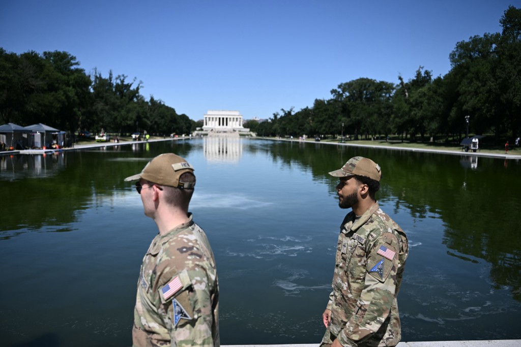 Photo by BRENDAN SMIALOWSKI / AFP  Soldiers walk near the Lincoln Memorial Reflecting Pool following the completion of recent renovations in Washington, DC, on June 16, 2026.