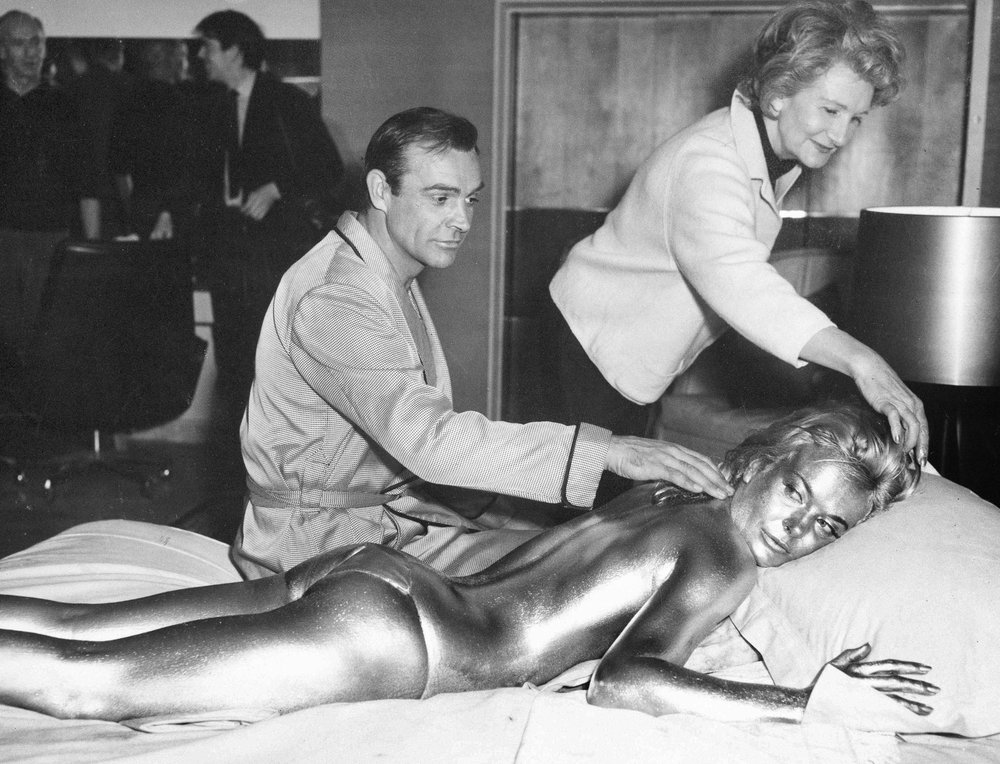In this file photo dated April 20, 1964, James Bond, alias, Sean Connery, finds himself in a sticky situation with actress Shirley Eaton at Pinewood Studios, near London. Miss Eaton was given a  coating of gold paint for a scene in Goldfinger, with u