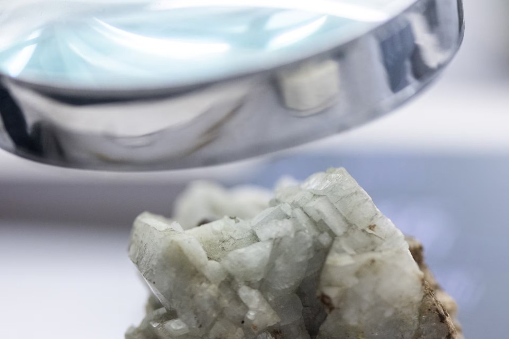 A sample of monazite, a mineral used in the rare earth industry to extract elements such as cerium, lanthanum, and neodymium, is displayed next to a magnification glass at the Geological Museum of China in Beijing, China, October 14, 2025. REUTERS