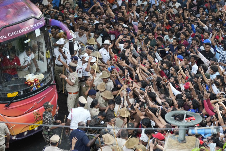 Fans cheer as the bus carrying Royal Challengers Bengaluru cricketers arrive at the M Chinnaswamy Stadium for their IPL title celebrations. (AP) 