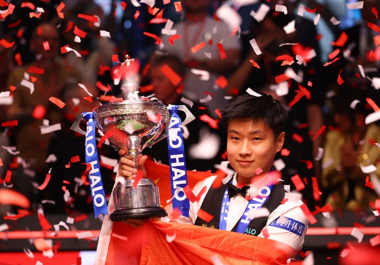 Zhao Xintong celebrates with the trophy after winning his final match against Mark Williams. REUTERS