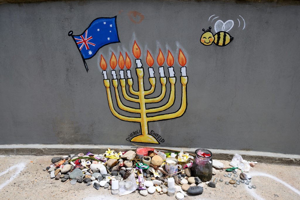 Photo by STEVEN MARKHAM / AFP  Tributes are seen on the overpass, where the attackers carried out their act of terror, in memory of the victims of December 14 Bondi Beach shooting in Sydney on January 22, 2026, as part of the national day of mourning.