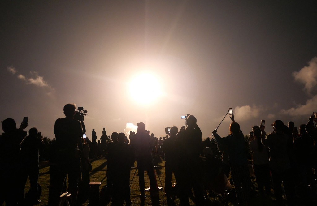 Photo by STR / JIJI PRESS / AFP  People watch the launch of the H3 rocket, carrying the Martian Moons eXploration (MMX) spacecraft, at the Tanegashima Space Center in Kagoshima Prefecture on October 20, 2026.