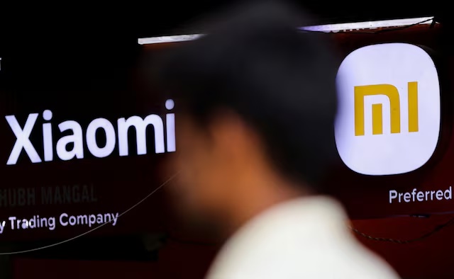 A man walks past a logo of Xiaomi, a Chinese manufacturer of consumer electronics, outside a shop in Mumbai, India, May 11, 2022. REUTERS/Francis Mascarenhas/File Photo
