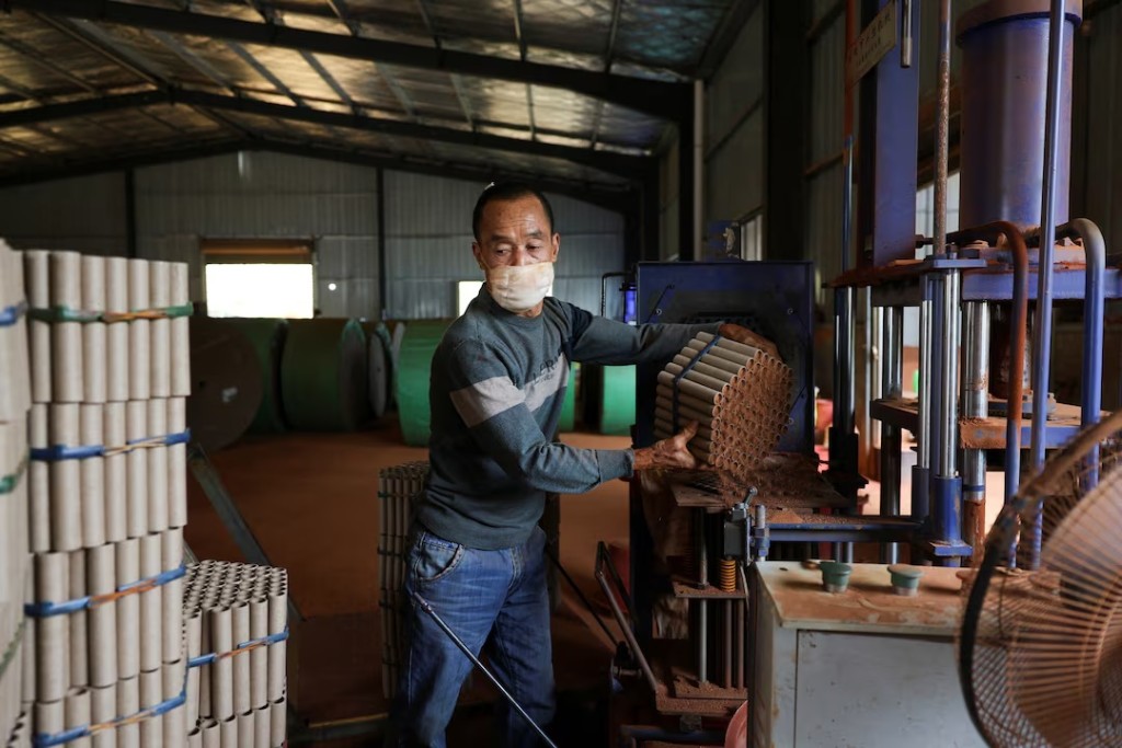 An employee works with a machine to assemble firework products at Chili Fireworks factory in Liling, Hunan province, China, April 9, 2026. REUTERS/Go Nakamura