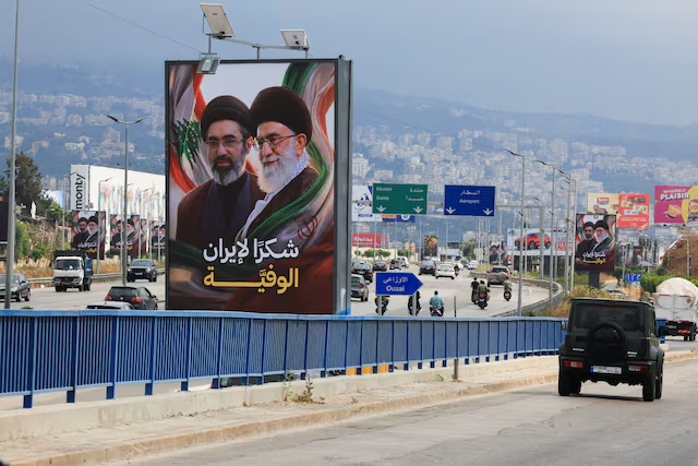Cars and motorbikes drive past billboards showing Iran’s new Supreme Leader Ayatollah Mojtaba Khamenei and his late father Ali Khamenei, with the slogan “Thank you to loyal Iran,” erected along the highway leading to Rafic Hariri International Airport in Beirut, Lebanon June 22, 2026.REUTERS/Mohamed Azakir