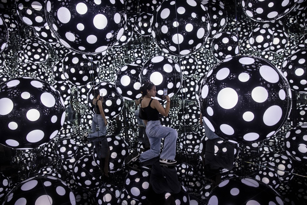 A woman takes photos at an art installation called Dots Obsession - Aspiring to Heaven’s Love by artist Yayoi Kusama’s with her signature polka dots and reflective mirrors in Hong Kong on August 4, 2023. (AFP) A woman takes photos at an art installation called Dots Obsession - Aspiring to Heaven’s Love by artist Yayoi Kusama’s with her signature polka dots and reflective mirrors in Hong Kong on August 4, 2023. (AFP)