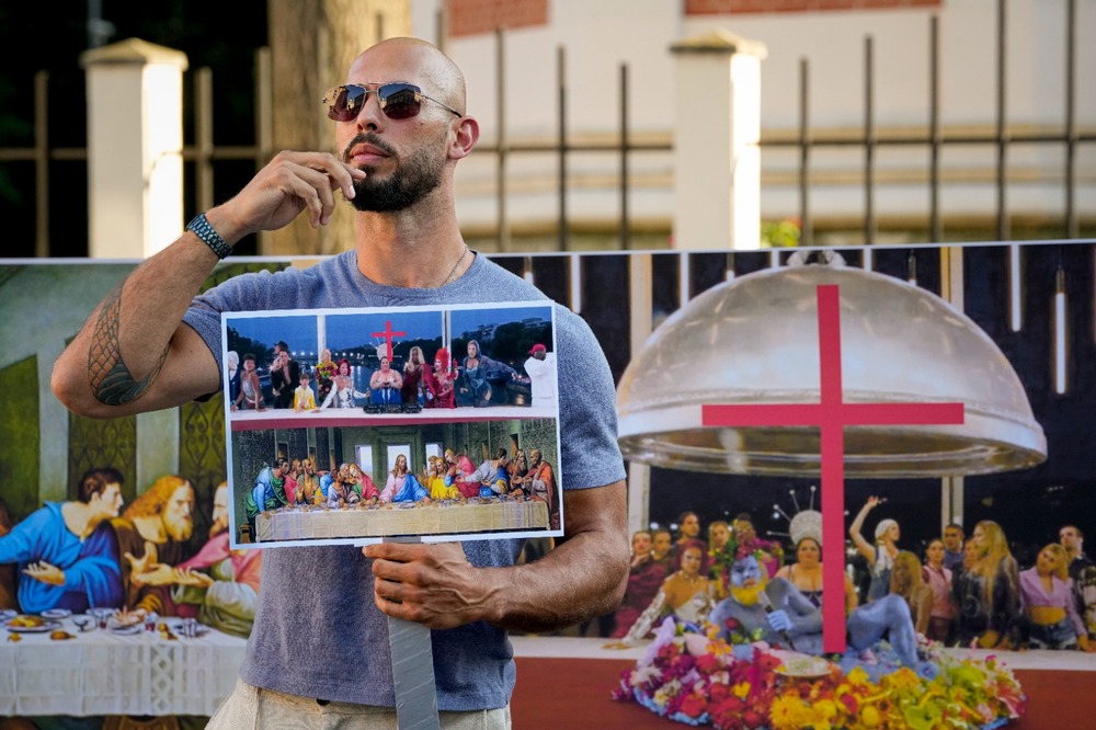 Social media influencer Andrew Tate gestures during a protest decrying a segment of the Paris Olympics opening ceremony, near the French Embassy in Bucharest, Romania, Sunday, July 28, 2024. (AP) Social media influencer Andrew Tate gestures during a protest decrying a segment of the Paris Olympics opening ceremony, near the French Embassy in Bucharest, Romania, Sunday, July 28, 2024. (AP)