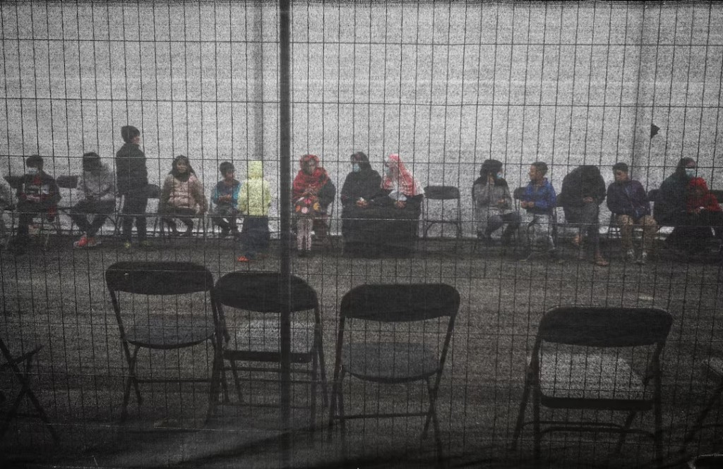 Afghan refugees queue outside a distribution and donation center at Liberty Village on Joint Base McGuire-Dix-Lakehurst in New Jersey, U.S., December 2, 2021. (Reuters)