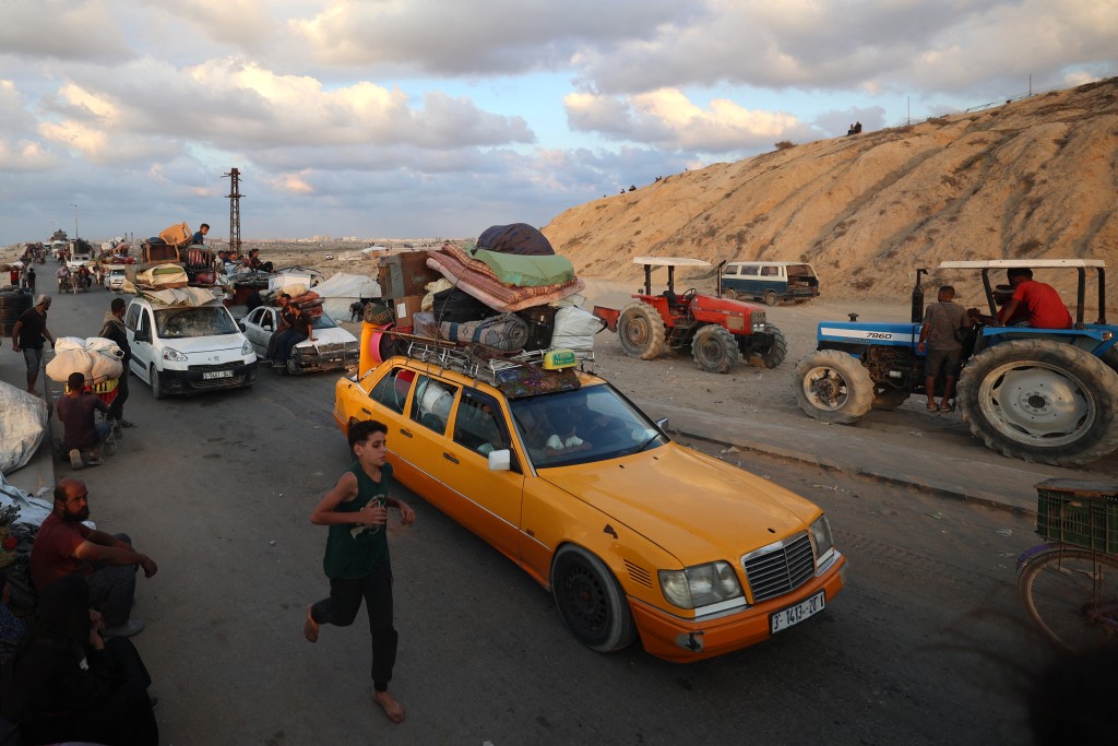 Displaced Palestinians move with their belongings southwards on a road in the Nuseirat refugee camp area in the central Gaza Strip on September 24, 2025, as Israel presses its air and ground offensive to capture Gaza City. Gaza's civil defence agency said Israeli forces killed dozens of people across the Palestinian territory on September 24, as the military pressed its assault on Gaza City that has displaced hundreds of thousands. (Photo by Eyad BABA / AFP)