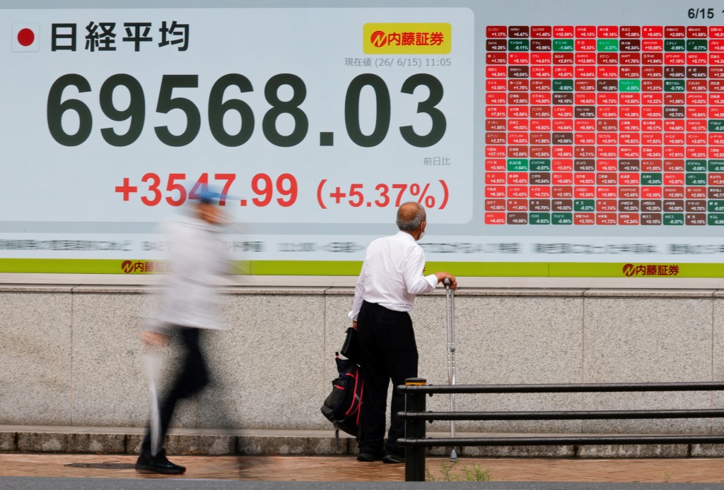 A man looks at a stock quotation board showing the Nikkei share average outside a brokerage in Tokyo, Japan, June 15, 2026. Picture taken with slow shutter speed. REUTERS