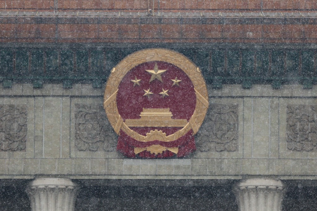 China's national emblem appears on the facade of the Great Hall of the People ahead of the annual National People's Congress (NPC), and the Chinese People's Political Consultative Conference (CPPCC) during heavy snowfall, in Beijing, China, March 4, 2026. (Reuters)