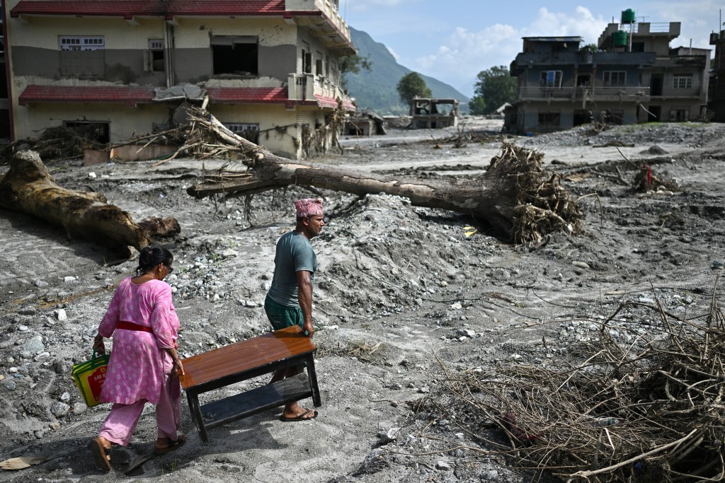 Photo by PEDRO PARDO / AFP People recover their belongings in the aftermath of flash floods at Devighat in Nepal's Nuwakot district on September 8, 2026.