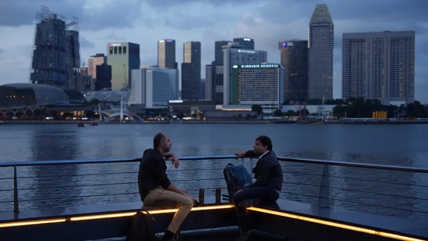 FILE – People talk along the bay in the evening in Singapore, on May 30, 2024. (AP Photo/Vincent Thian, File)