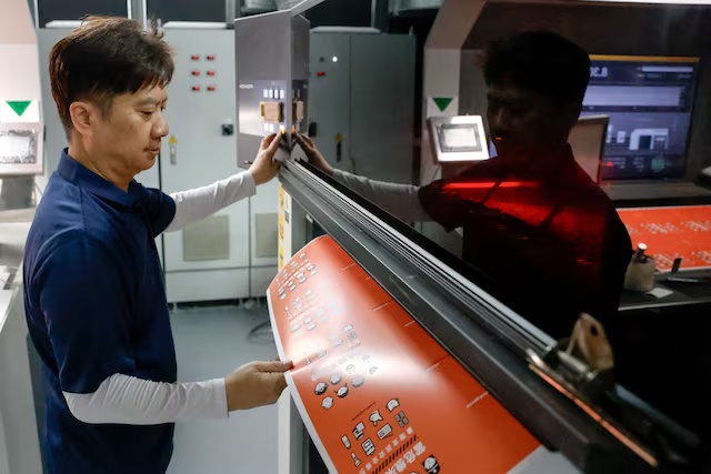 A worker checks the printed book cover of Taiwan's civil defence handbook at a printing house in Taoyuan, Taiwan, November 14, 2025. REUTERS/Ann Wang