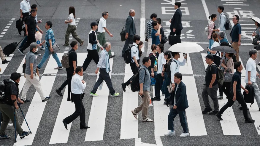 People walk along a pedestrian crossing at a shopping street Wednesday, June 4, 2025, in Tokyo. (AP Photo/Eugene Hoshiko)
