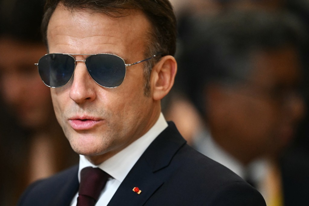 Photo by NICOLAS TUCAT / AFP. France's President Emmanuel Macron wearing sunglasses speaks to the press as he arrives for a European Council meeting to discuss recent developments in transatlantic relations, in Brussels, on January 22, 2026.