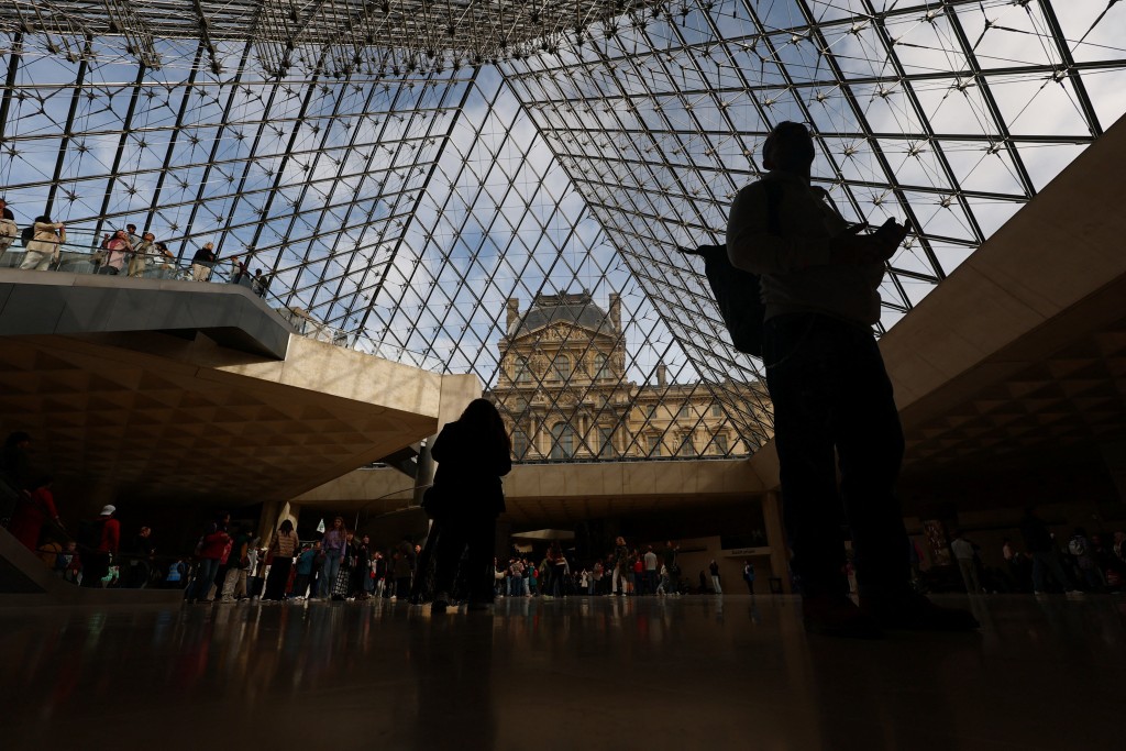 Visitors walk below the glass Pyramid at the Louvre Museum on the day it reopened to the public for the first time since last Sunday's heist, while the Galerie d'Apollon where eight pieces of Napoleon and the Empress's jewelry collection displayed in the gallery were stolen by thieves, remains closed, in Paris, France, October 22, 2025. (Reuters)