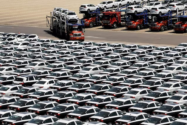A carrier trailer transports newly manufactured cars at a port in Dalian, Liaoning province, China May 21, 2019. REUTERS/Stringer/File Photo