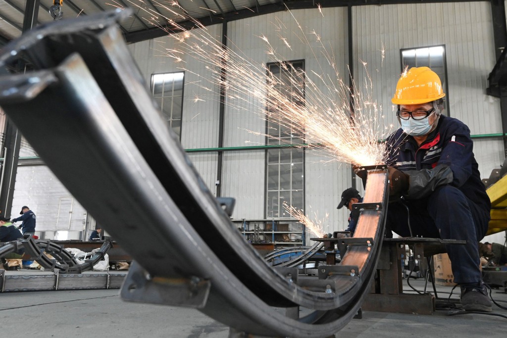 An employee works in a ball bearing factory in Handan, in northern China's Hebei province on November 24, 2025.  AFP