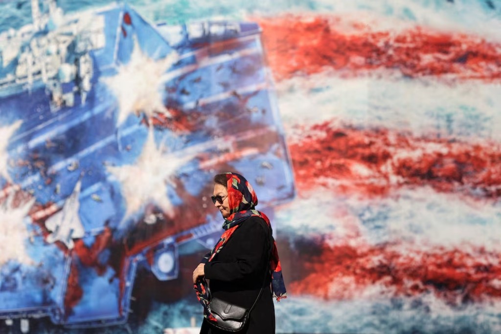 An Iranian woman walks past an anti-U.S. billboard in Tehran, Iran, February 26, 2026. Majid Asgaripour/WANA (West Asia News Agency) via REUTERS