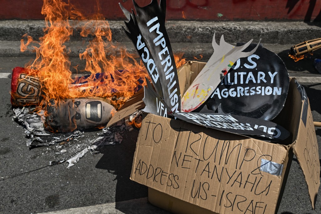 Demonstrators burn props during a protest against the US-Israel military action in Iran, near the US Embassy in Manila on April 9, 2026. (Photo by Jam STA ROSA / AFP)