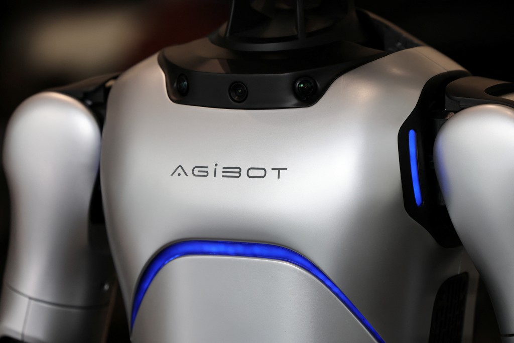 An AgiBot humanoid robot stands at a China Yongda Automobiles Services Holdings Ltd. car dealership, in Shanghai, China, April 8, 2025.  REUTERS/Go Nakamura