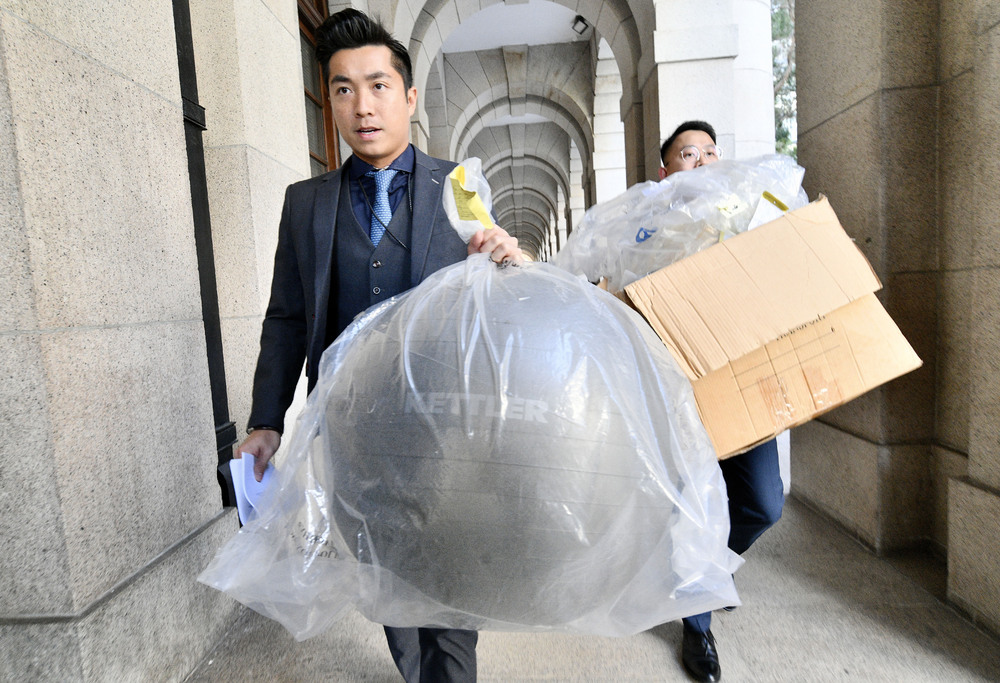 Evidence including the yoga ball in the case against Khaw Kim Sun – who is shielded by an inflatable tunnel – is transferred from court. The case involves the deaths of Wong Siew-fing and Lily Khaw. SING TAO