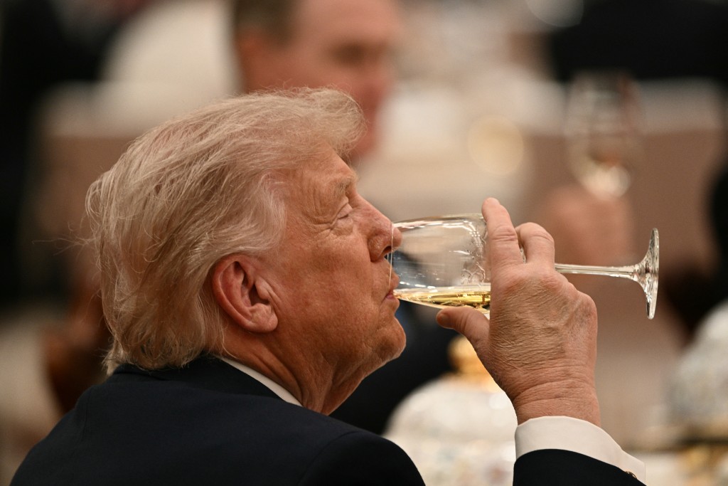 US President Donald Trump drinks as he attends a state banquet with China's President Xi Jinping at the Great Hall of the People in Beijing on May 14, 2026. (AFP)