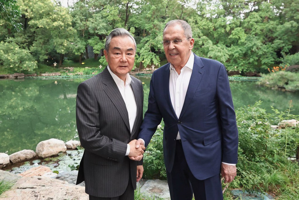 This handout photograph released by the Russian Foreign Ministry shows Russian Foreign Minister Sergey Lavrov (R) and Chinese Foreign Minister Wang Yi shaking hands during a meeting in Beijing on July 13, 2025. (AFP)
