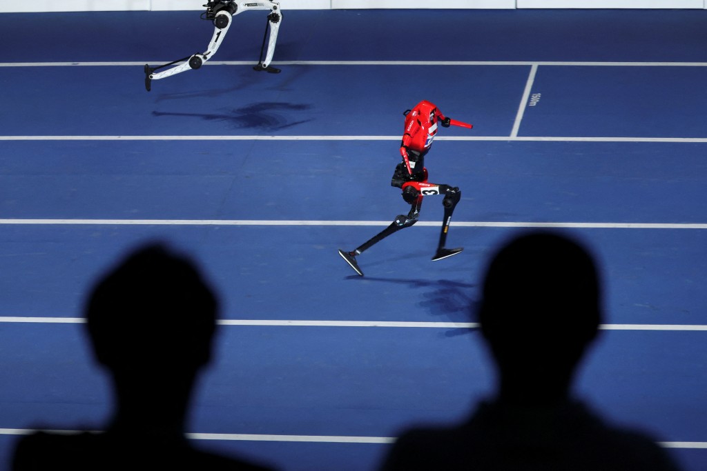 Spectators watch as a Lightning humanoid robot by Honor and a Tiangong Ultra humanoid robot compete in a 100m exhibition race during the opening ceremony for the second World Humanoid Robot Games at the National Speed Skating Oval in Beijing, China August 22, 2026. (Reuters)
