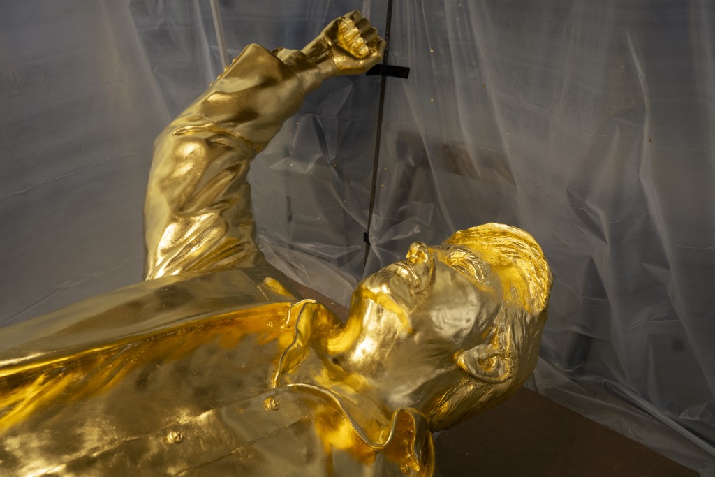 Photo by ELI HILLER / AFP  The bust portion of a 15-foot bronze statue of US President Donald Trump, coated in gold leaf, lies on its back in the studio of sculptor Alan Cottrill in Zanesville, Ohio on February 5, 2026.