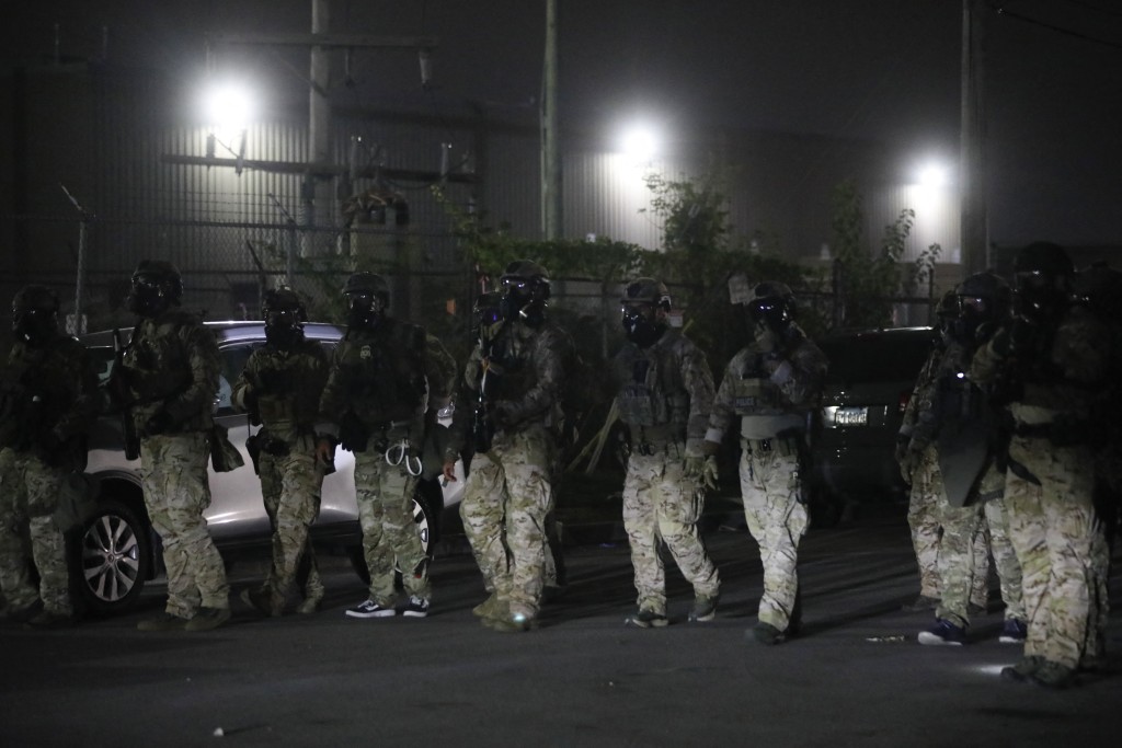 Immigration and Customs Enforcement (ICE) and Special Response Team Police agents line up outside an ICE processing center during a protest in Broadview, Illinois, on September 19, 2025. US President Donald Trump ordered increased federal law enforcement presence in Illinois and stepped-up immigration enforcement actions by the Department of Homeland Security. (Photo by OCTAVIO JONES / AFP)
